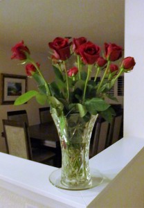 A dozen red roses in a cut glass vase