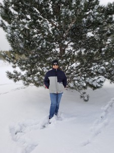 The author standing in front of a green tree in the snow