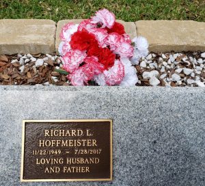 pink and white flowers at memorial marker