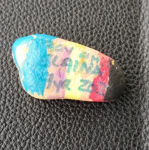 Small rock painted many colors with names on it