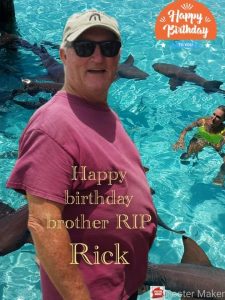 Rick with sharks in water in the background