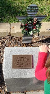 Rick's memorial stone with metal angel behind and Christmas wreath