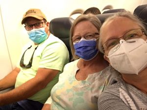 Tommy, Jackie, and Renee on a plane wearing masks