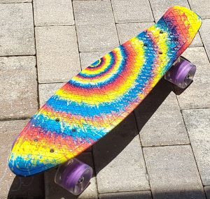 A very brightly tie-died colored skateboard