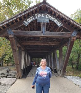 Jackie in front of a covered bridge
