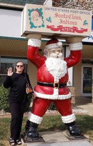 Charlene standing next to a statue of Santa Claus at the Indiana Post Office