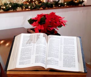 Open Bible with flowers and garland behind