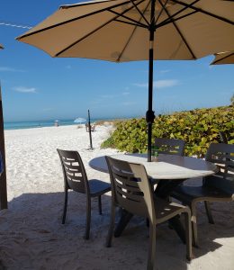 Table on the sand with umbrella overlooking the beach