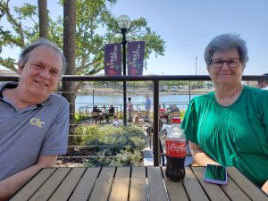 Bill and Mary sitting outside at a table on the Tampa Riverwalk at the Straz Center before the show