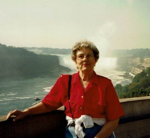 Woman standing in front of Niagra Falls wearing a red shirt