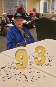 Tom Cambre sitting at table with gold numbers 93