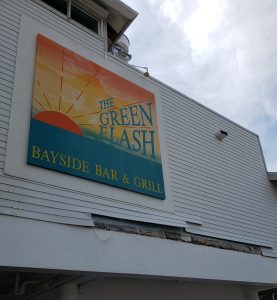 Front of Green Flash building with wind damage to the siding