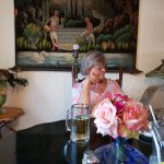 Jackie sitting at table reading menu with bowl of roses in the foreground