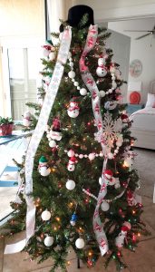 Christmas tree decorated with snowman ornaments and ribbons