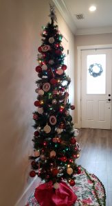 Decorated pencil tree with front door with wreath in the background