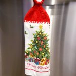 A Christmas dishtowel with a crocheted hanger on top