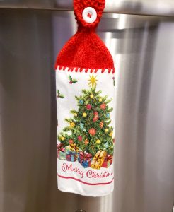 A Christmas dishtowel with a crocheted hanger on top