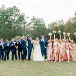 Men in blue and ladies in peach flank the bride and groom